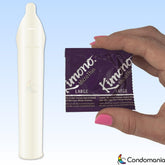 A hand with pink nail polish holds a Kimono MicroThin Large Size Condoms package, emphasizing its natural sensations in purple packaging, next to an unrolled thin condom. The Condomania logo is positioned at the bottom right corner against a blue gradient background.